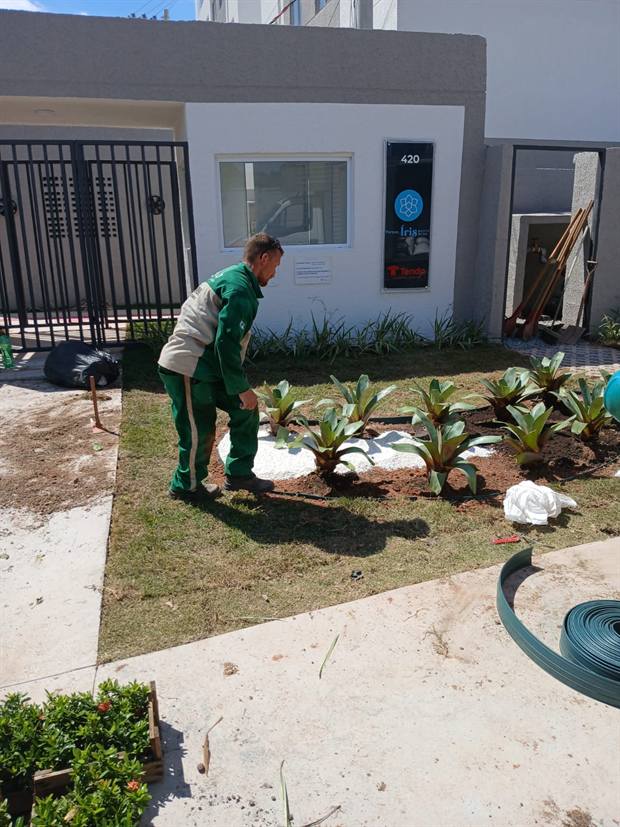 A mesma portaria durante a obra, com o canteiro em terra e a equipe plantando