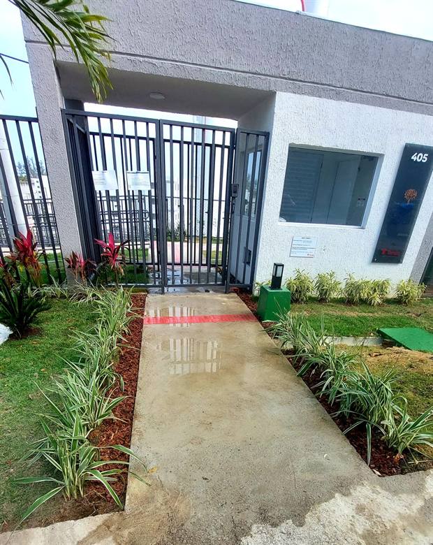 Entrada de condomínio com canteiros e passeio