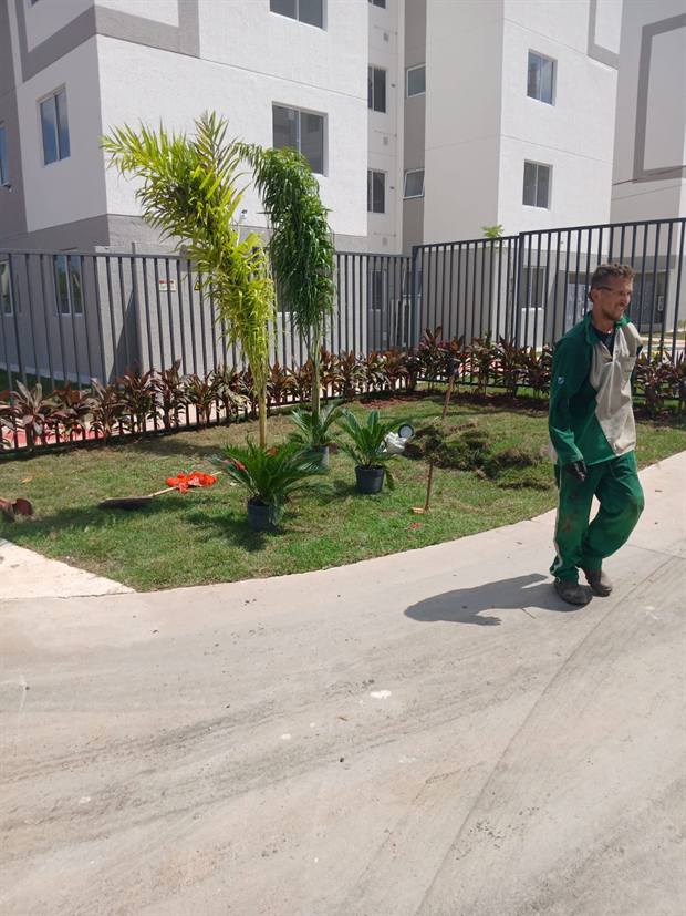Profissional realizando manutenção de jardim em condomínio